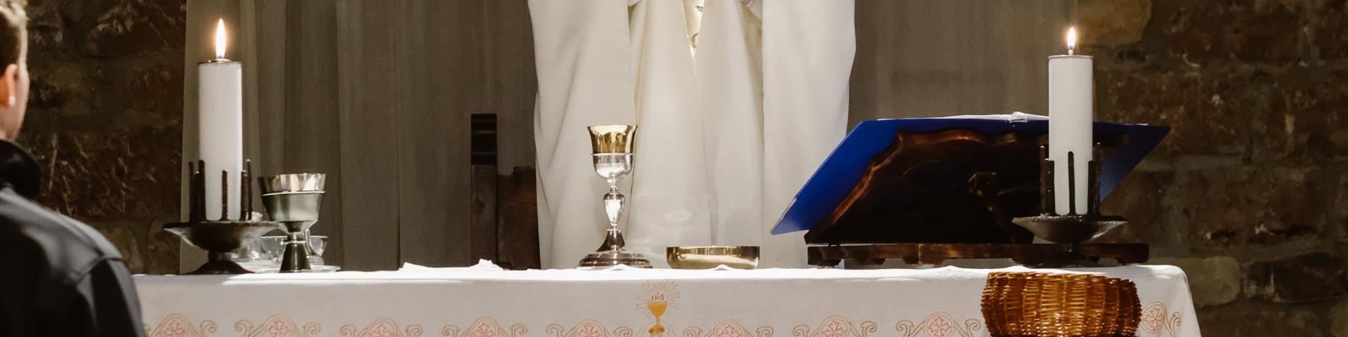 Priest holding up the Eucharist during consecration 