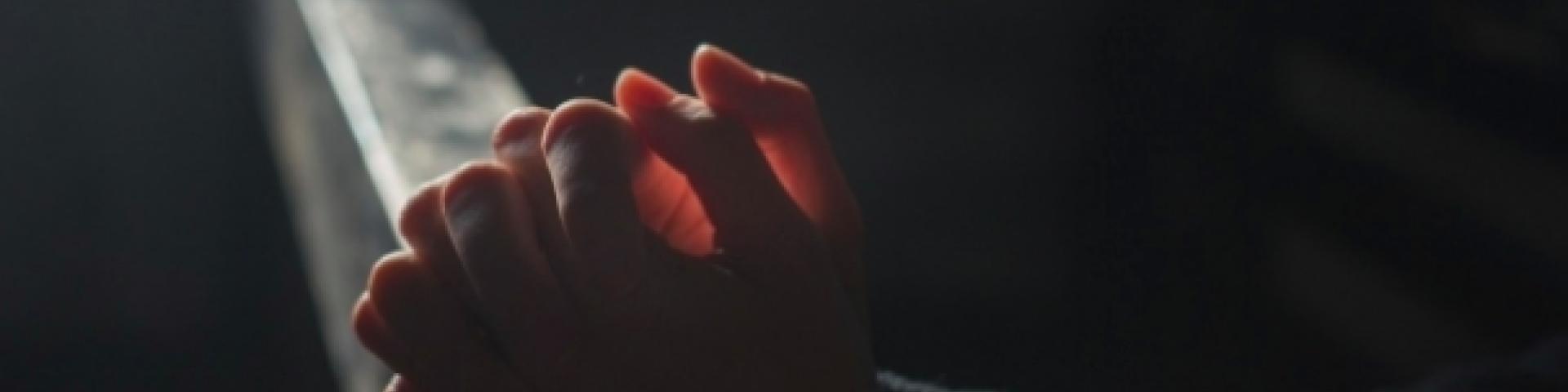 A person's hands folded in prayer 