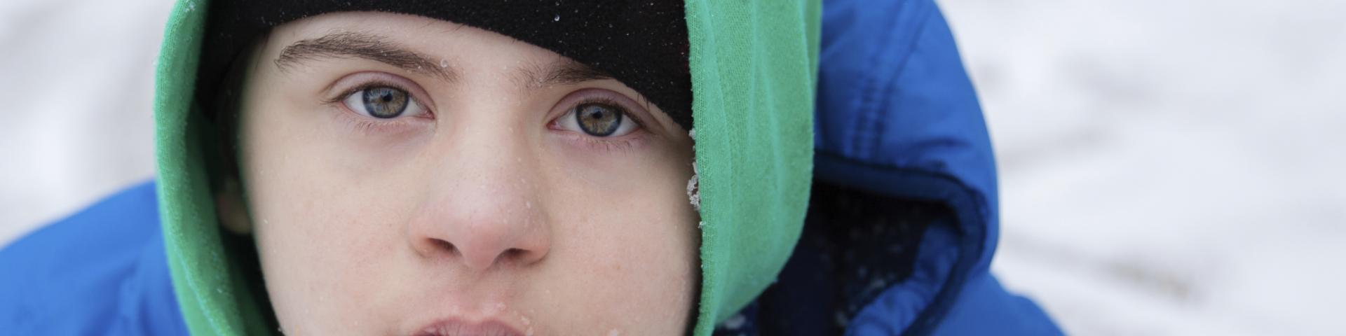 A boy in a winter setting looking at the camera