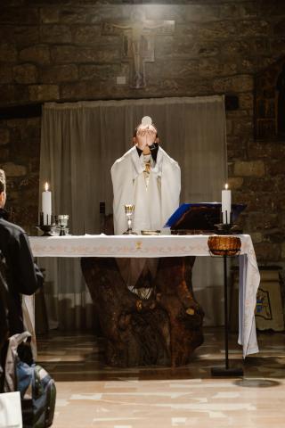 Priest holding up the Eucharist during consecration 