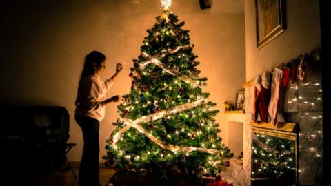Young girl decorating a Christmas tree