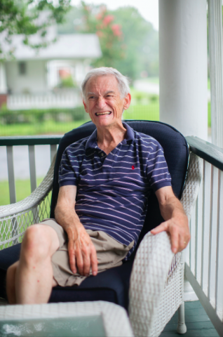 Martin sitting in a chair, smiling. 