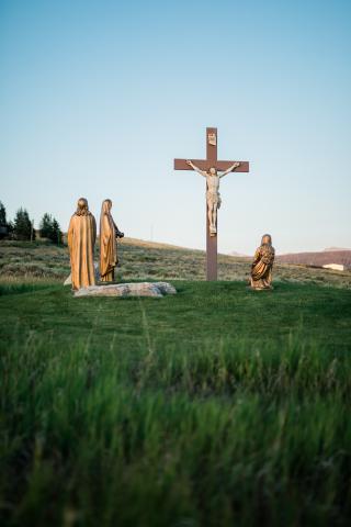 Crucifix in a field with  statue of Mary and Saint John 