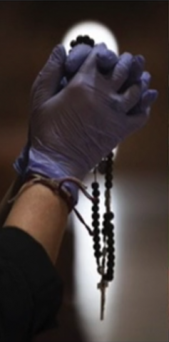 Person praying a rosary with gloves