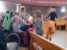 A sign language interpreter and a child in a wheel chair at Mass 
