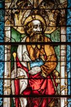 close-up of a stained glass window: a man holding a book