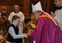 Child bringing the gifts to the altar during Mass