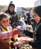 Aid workers giving out food at a refugee camp.